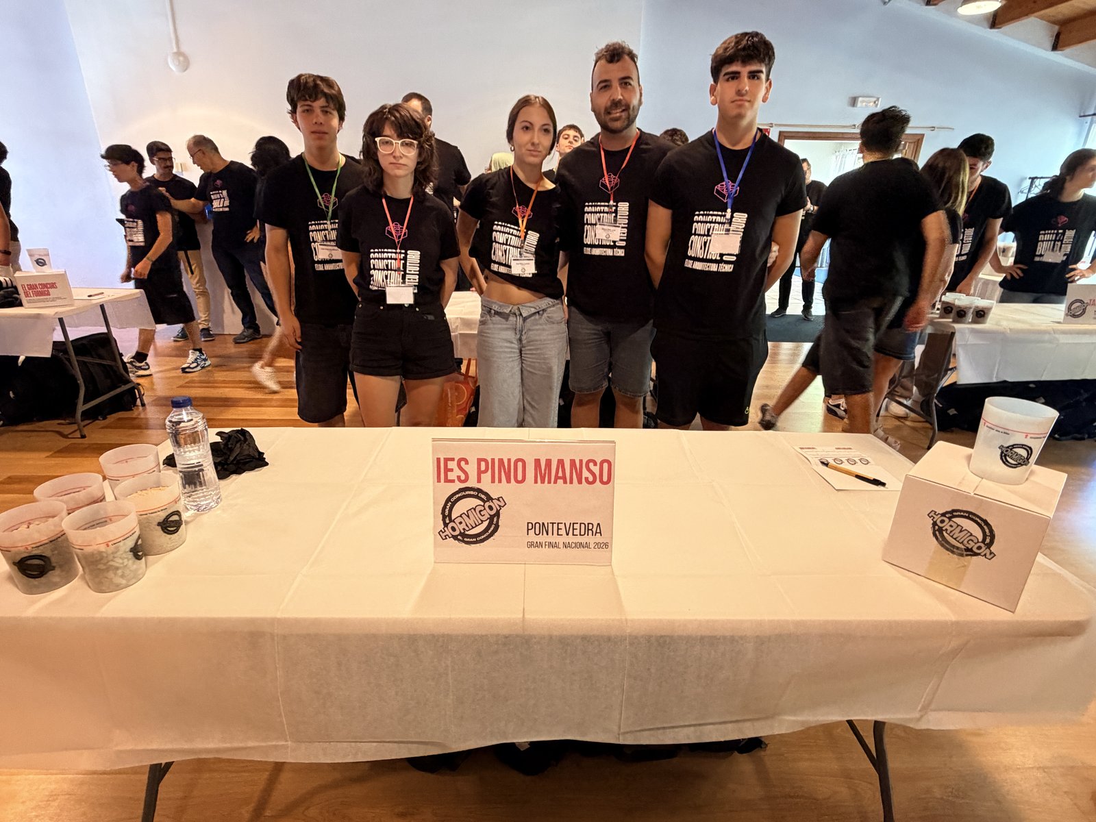 Alumnos y docente del IES Pino Manso de O Porriño (Pontevedra) en su puesto de la Gran Final Nacional 2026 de El Gran Concurso del Hormigón en El Escorial acompañados por el COATPO