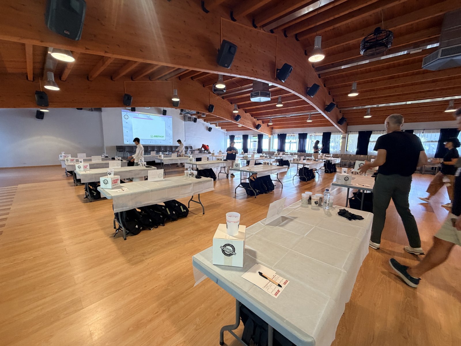 Vista de la sala en El Escorial durante el montaje de las mesas y materiales para los 29 equipos finalistas de El Gran Concurso del Hormigón