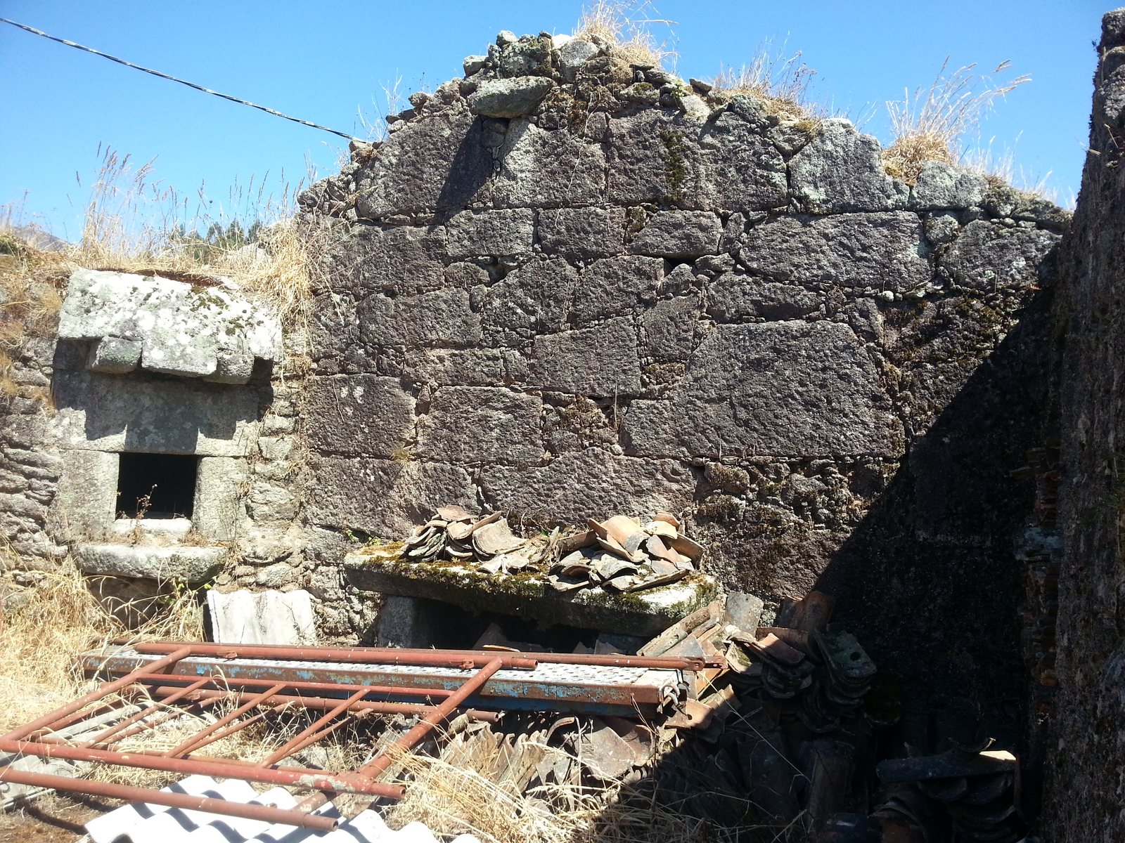 Horno de piedra tradicional gallego y muros interiores en ruina antes de la reforma en Tui