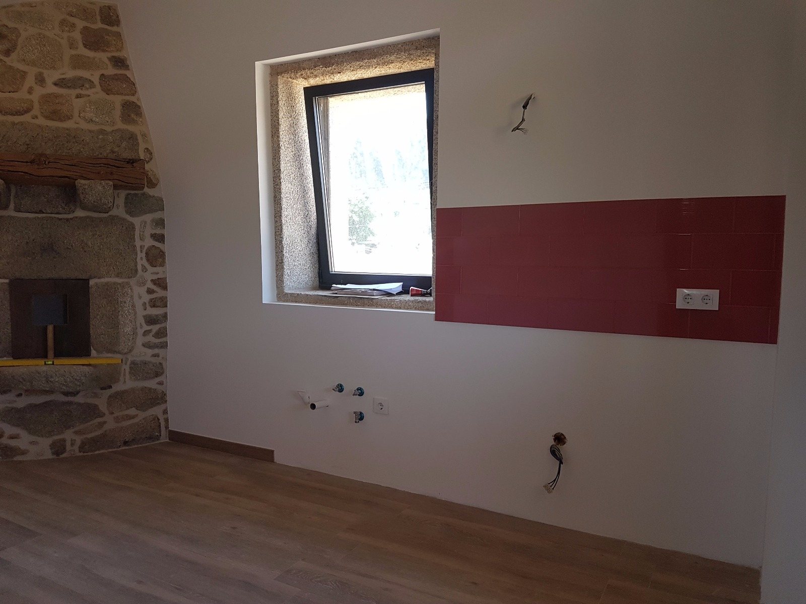Horno antiguo de piedra reconstruido junto a ventana con recercado de granito en reforma de vivienda en Tui