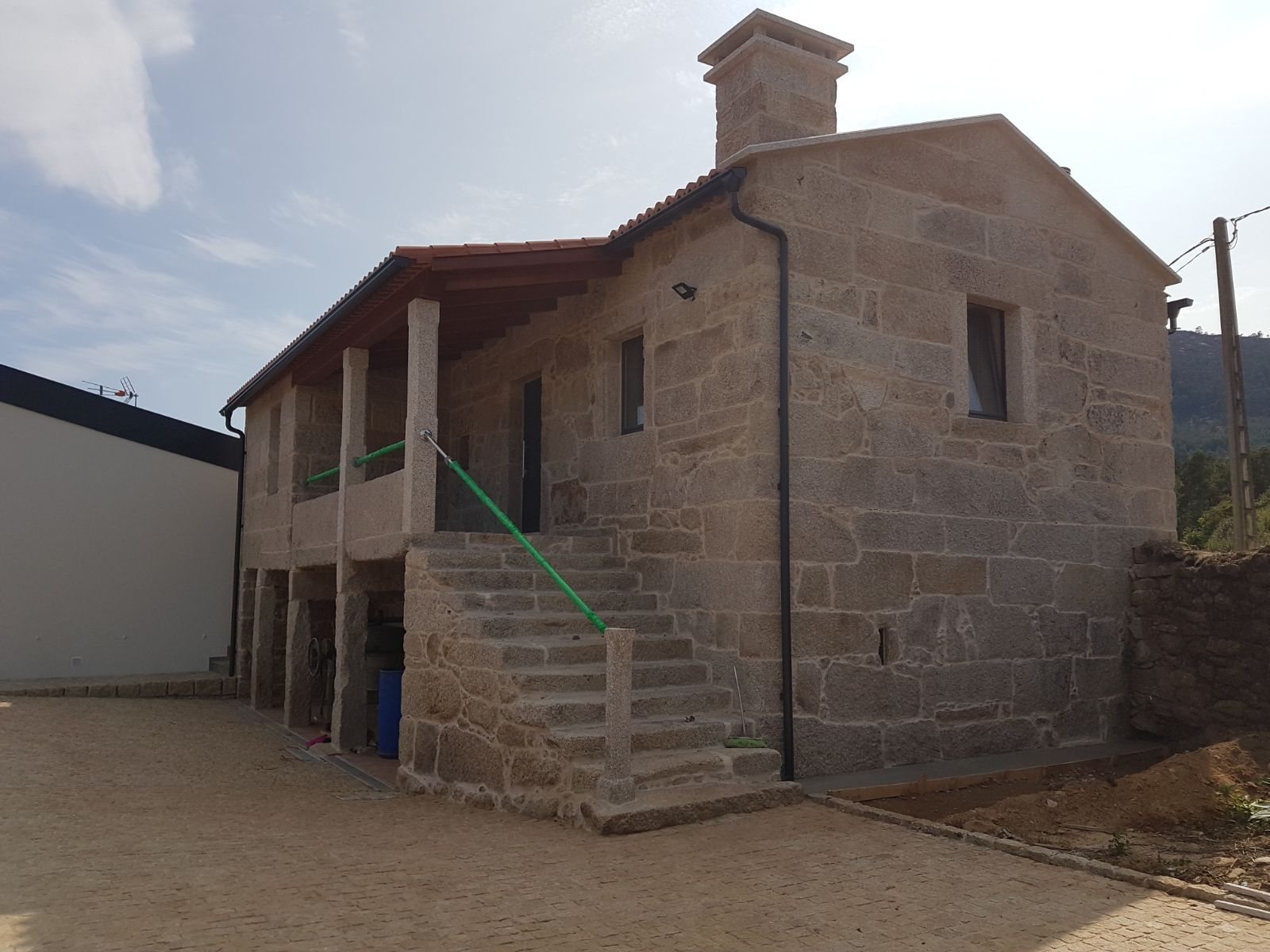 Vivienda tradicional de piedra rehabilitada con patín y nuevo cuerpo moderno adosado en Tui (Pontevedra)