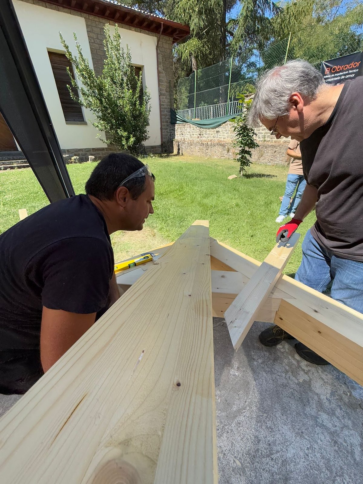 Pablo Freiría Lorenzo y el maestro carpintero verificando el encaje de un par de madera en la estructura de cubierta en Jaca