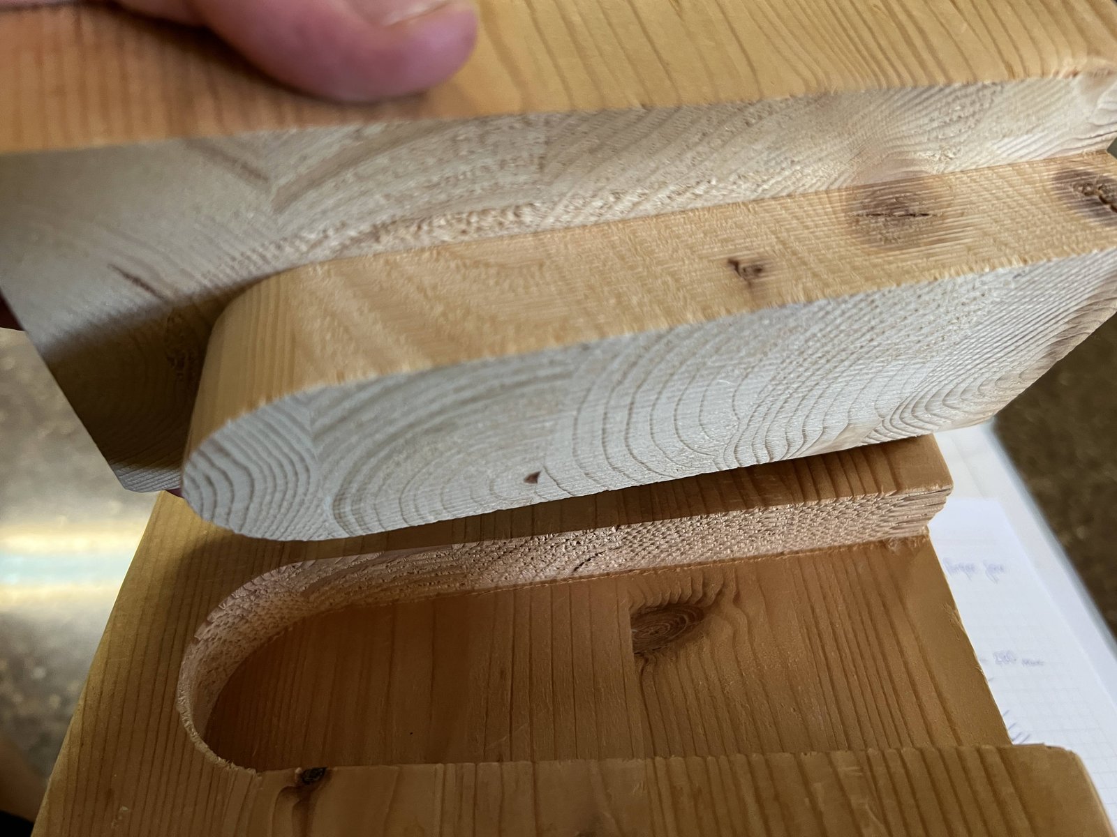 Detalle de dos piezas de madera unidas mediante un ensamble de caja y espiga curva tallada a mano