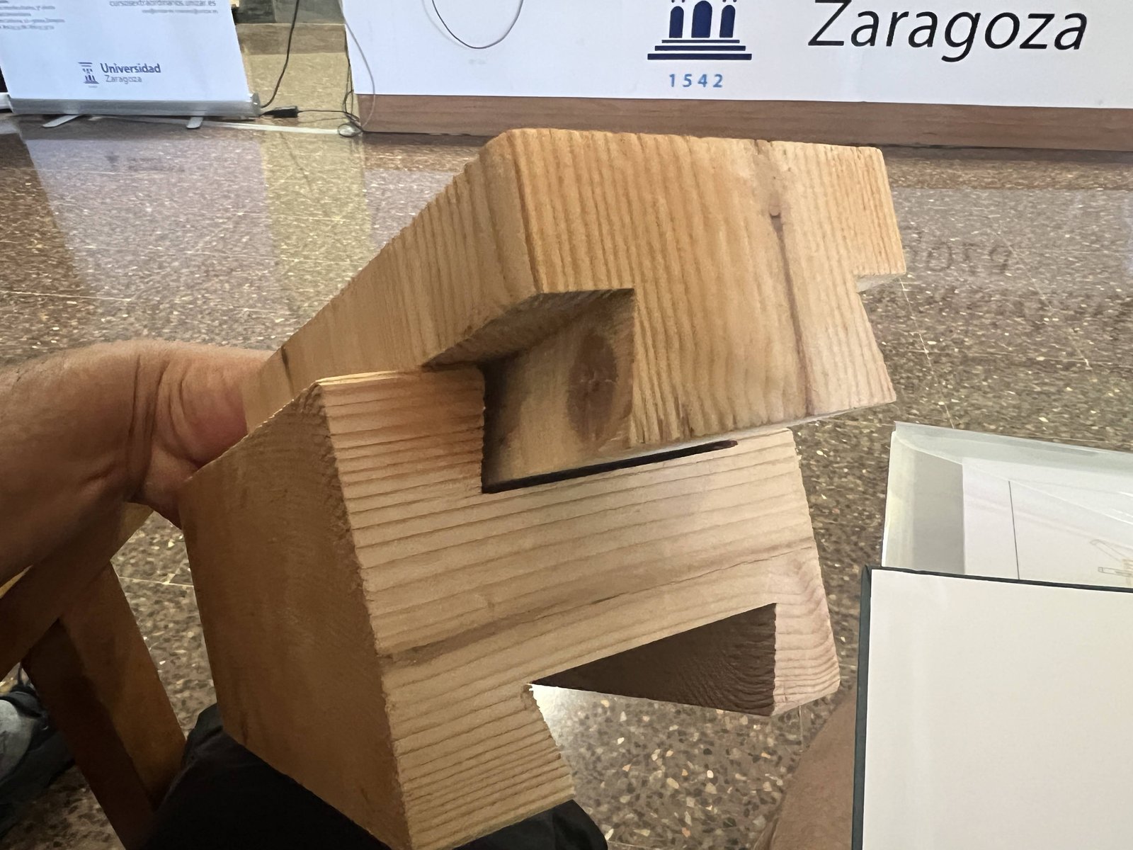 Dos piezas de madera unidas mediante un empalme en rayo de Júpiter sobre una mesa de aula