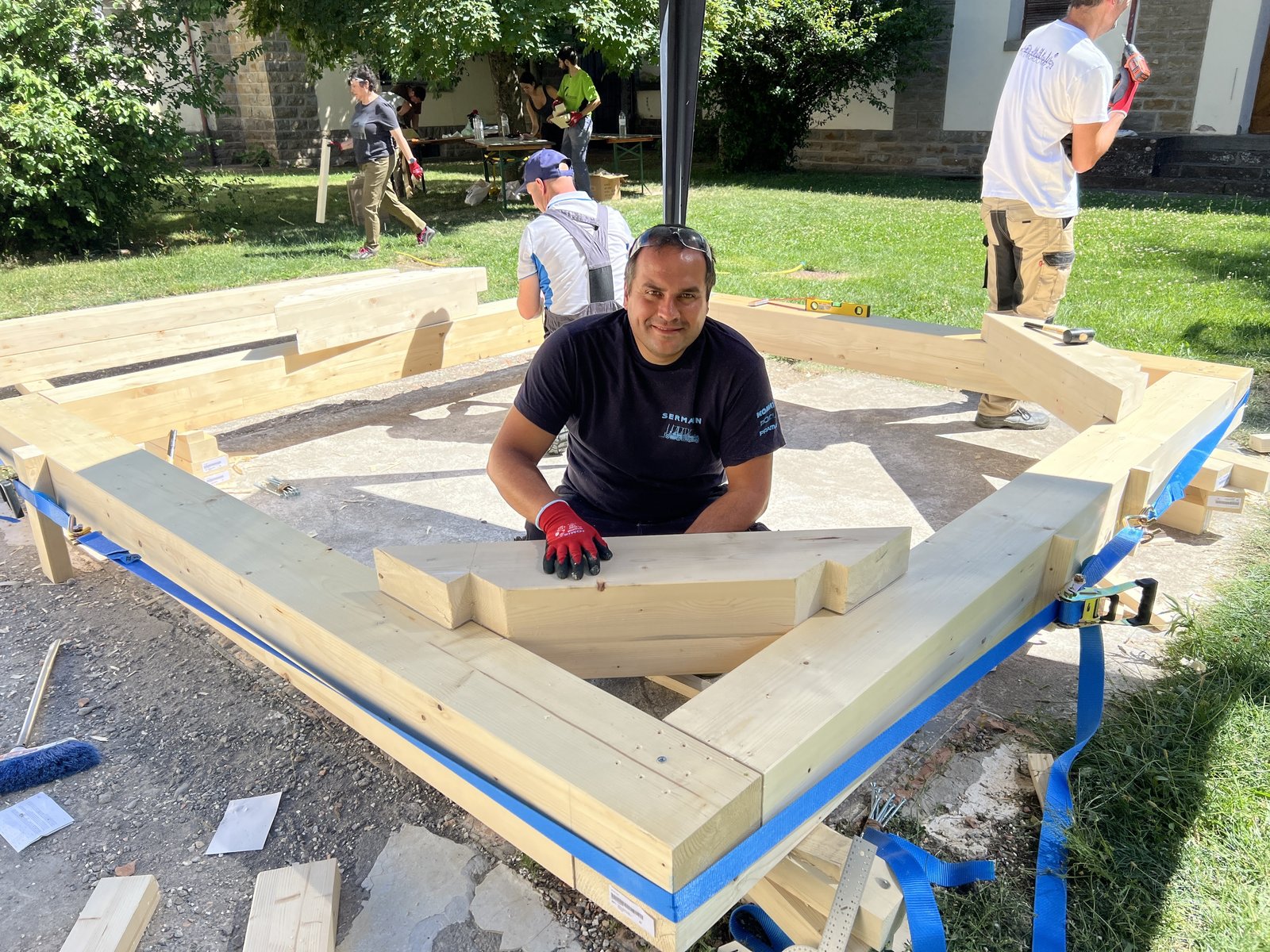 Pablo Freiría Lorenzo colocando una pieza de madera con ensamble artesanal en la esquina de la estructura de cubierta en el taller de Jaca