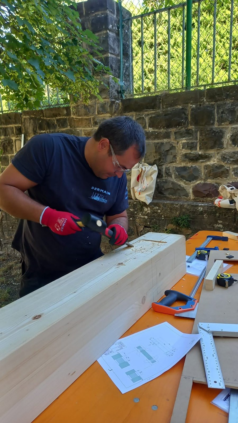 Pablo Freiría Lorenzo tallando un ensamble en una viga de madera con formón y maza de carpintero en el taller de Jaca