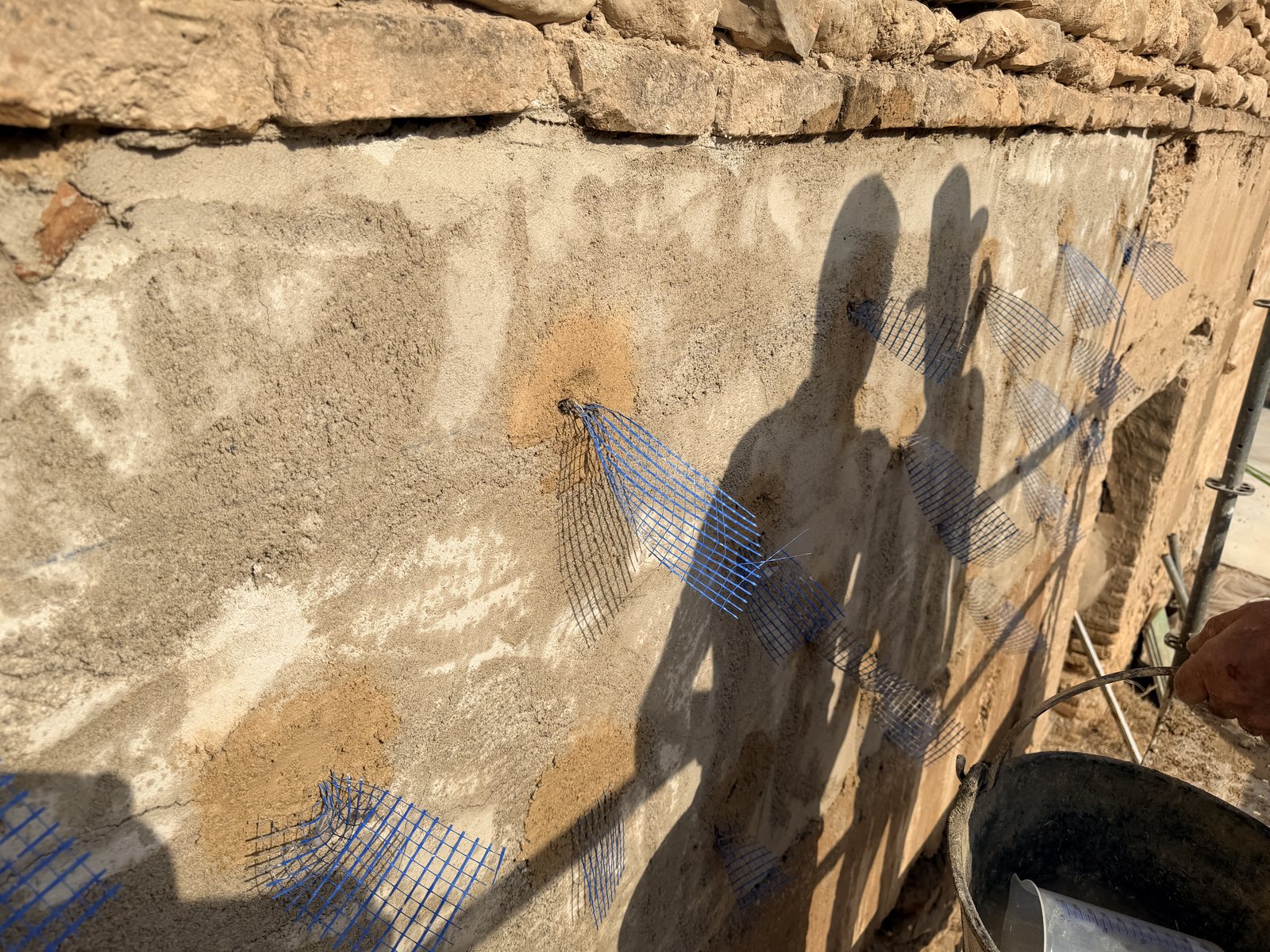 Restauración de un muro histórico erosionado en la Cartuja de los Monegros mediante anclajes con malla de fibra de vidrio y reintegración con tierra y cal